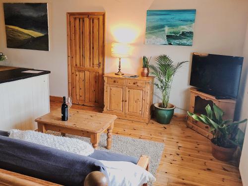 a living room with a couch and a table at Bantham Beach Pad in Thurlestone