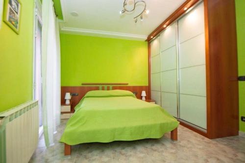 - une chambre verte avec un lit et une couverture verte dans l'établissement Casa Manuel, à Alcañiz