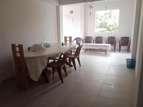 een eetkamer met een lange tafel en stoelen bij Kandyan Guest house in Kandy