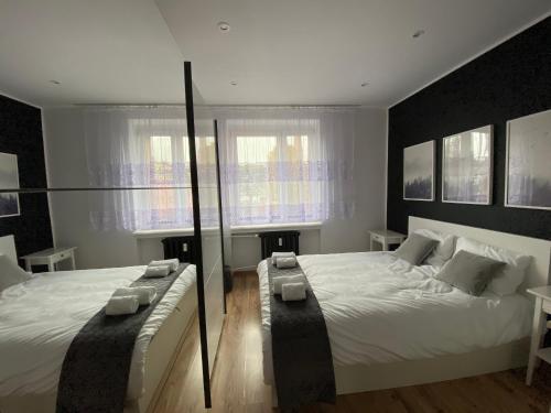 sypialnia z dużym białym łóżkiem i 2 oknami w obiekcie Apartament w samym centrum! w mieście Dąbrowa Górnicza