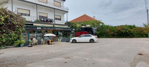 a white car parked in front of a building at Alojamento da Avó Maria in Pombal