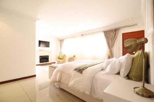 - une chambre blanche avec un grand lit et une fenêtre dans l'établissement Smartz Luxury Home, à Centurion