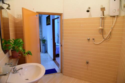 a bathroom with a sink and a shower at The Tree House in Hikkaduwa