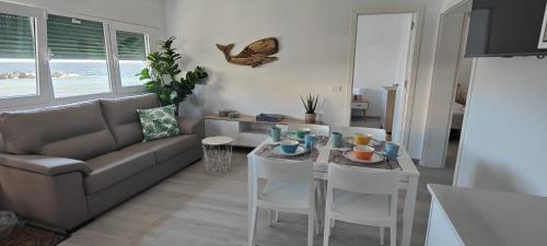 ein Wohnzimmer mit einem Sofa, einem Tisch und Stühlen in der Unterkunft Vistamar in Las Eras