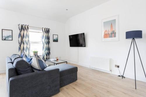 a living room with a couch and a tv at Top Floor, City Centre, Parking in Belfast