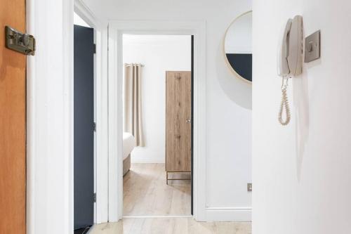 een hal met een spiegel en een deur naar een badkamer bij Top Floor, City Centre, Parking in Belfast