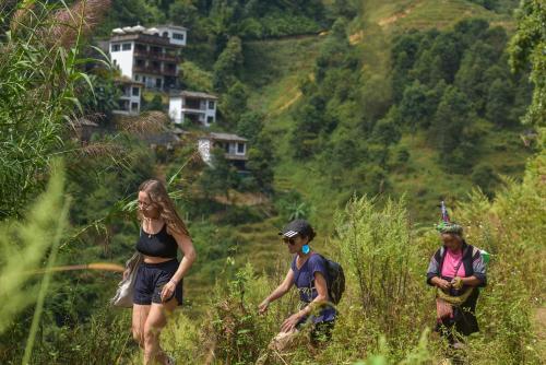 a group of people walking up a hill at Maison de Lao Chai in Sa Pa