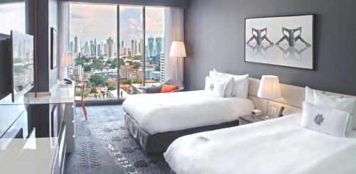 a hotel room with two beds and a large window at Sortis Hotel, Spa & Casino, Autograph Collection in Panama City