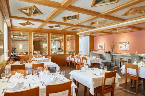 un comedor con mesas y sillas blancas en Hotel Rotes Haus en Brugg