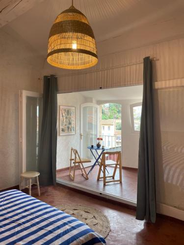 1 dormitorio con 1 cama y 1 mesa con sillas en Sole Mio, T2 avec loggia et petit aperçu mer, en Bormes-les-Mimosas