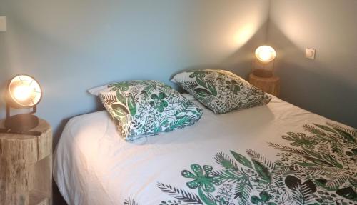 a bedroom with a bed with two pillows on it at Le Relax in Corgnac-sur-lʼIsle