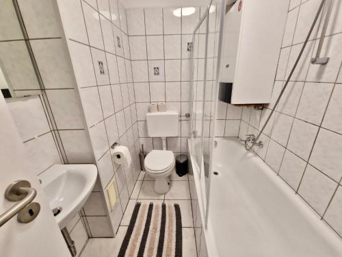 La salle de bains est pourvue de toilettes, d'une baignoire et d'un lavabo. dans l'établissement Bis 4 Pers. 0,3 km zur City von Wuppertal – neuwertige Wohnung, à Wuppertal