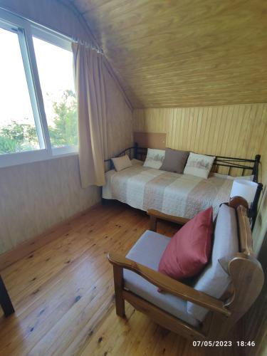 a bedroom with a bed and a couch and a window at Σοφίτα Μαρτά in Kalamos