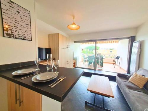 勒格罗-迪鲁瓦Studio CLIM Terrasse Privée - Proche de la Plage的带桌子的厨房和客厅