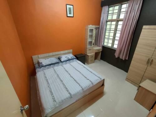 1 dormitorio con 1 cama con pared de color naranja en Crown imperial en Brinchang