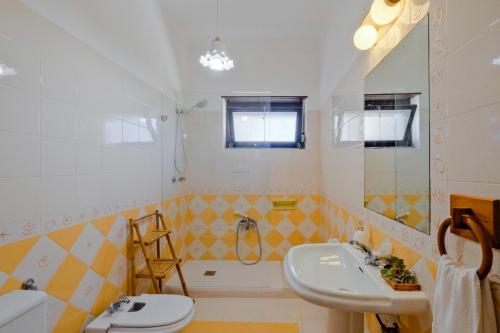 een badkamer met een wastafel, een toilet en een bad bij Villa Magoito in Sintra