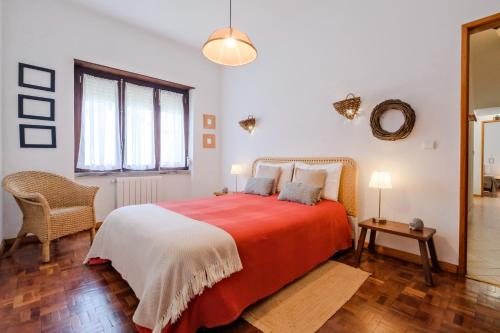 een slaapkamer met een groot bed met een rode deken bij Villa Magoito in Sintra