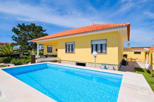 a villa with a swimming pool in front of a house at Villa Magoito in Sintra