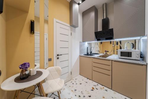 a kitchen with a table and chairs and a microwave at InshiApartments on Vahylevycha Str in Lviv