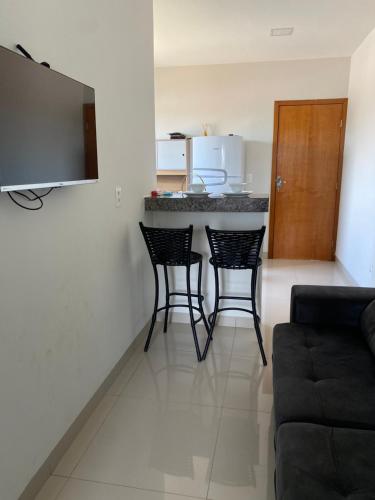 a living room with a counter and two chairs at Flat Delior 07 in Palmas