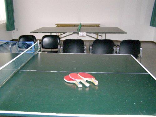 a ping pong table in a room with chairs at Hotel Masyu in Teshikaga