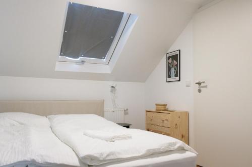 um quarto com uma cama branca e uma janela em City Apartments Dornbirn Gemütliches Apartment im Stadtzentrum Dornbirn, Kopenhagen 5 em Dornbirn