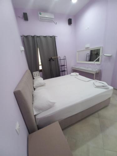 1 dormitorio con 1 cama grande y espejo en Sappho Hotel en Skála Eresoú