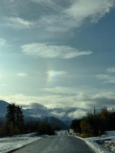 an empty road with a rainbow in the sky at 3ART recreation in Tromsø