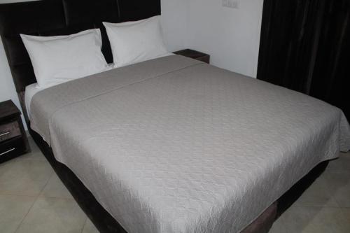 a bed with white sheets and pillows in a room at Residence tafoult imi ouadar taghazout in Imi Ouaddar