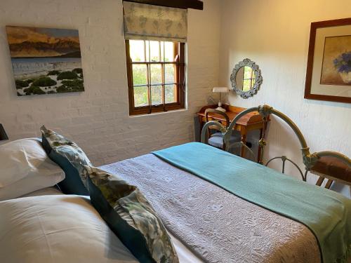 1 dormitorio con 2 camas y ventana en Hidden Stream Cottage, en Bettyʼs Bay