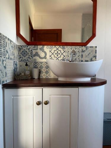 a bathroom with a sink and a mirror at Hidden Stream Cottage in Bettyʼs Bay