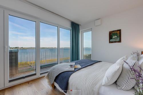 a bedroom with a bed with a view of the ocean at Ferienhaus Nordlicht Olpenitz in Olpenitz