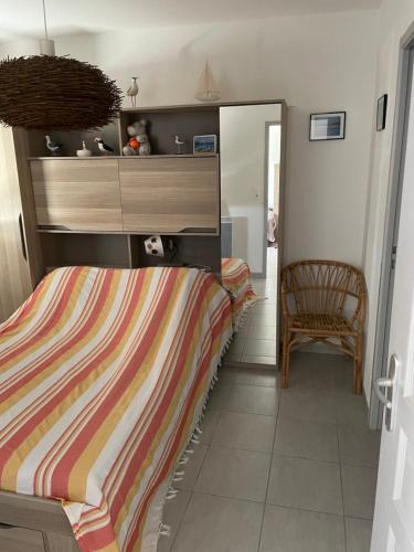 a bedroom with a bed and a chair and a mirror at Appartement Narbonne in Narbonne