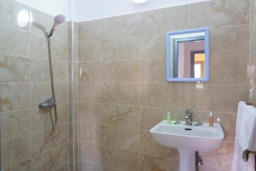 a bathroom with a sink and a shower at Hotel Warda in Ouarzazate