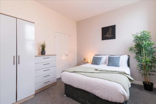 a bedroom with a bed and a dresser and a mirror at cheerful double en-suite room with free wifi in Derby