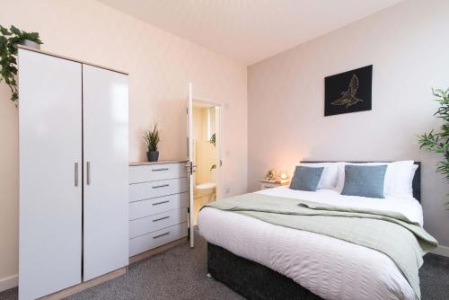 a bedroom with a large white bed and a dresser at cheerful double en-suite with free wifi in Derby