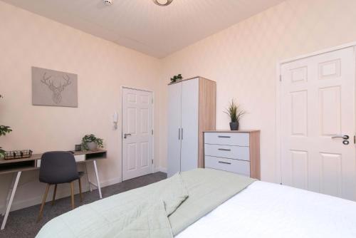 a bedroom with a bed and a desk and a chair at cheerful double en-suite with free wifi in Derby