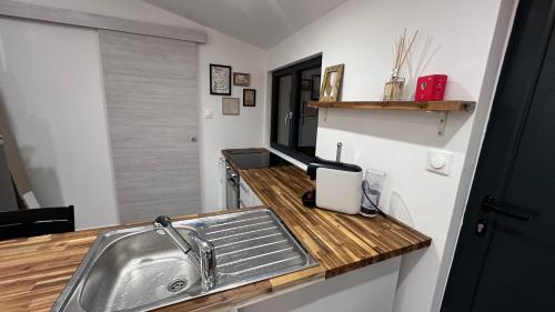 cocina con fregadero y encimera de madera en LA VILLA DEKO - Studio indépendant, en Beuvry