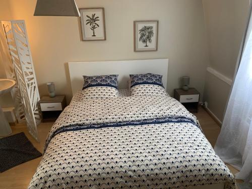 a bedroom with a bed with a black and white comforter at chambre cosy in Annappes