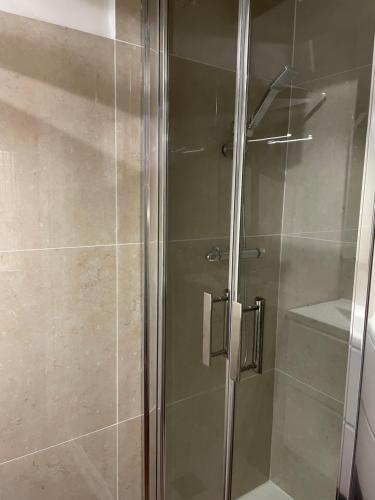 une douche avec une porte vitrée dans une salle de bain dans l'établissement Sole Mia, appt 2/4pers au cœur de Bormes, à Bormes-les-Mimosas