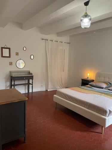 une chambre avec un lit et un bureau dans l'établissement Sole Mia, appt 2/4pers au cœur de Bormes, à Bormes-les-Mimosas