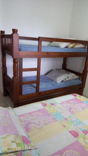 two bunk beds in a room with a bed at Apto Praia Grande - Guilhermina in Praia Grande