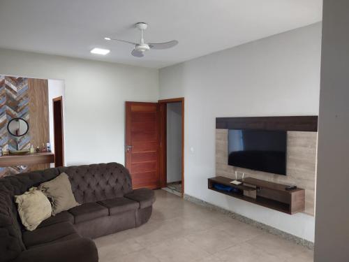 sala de estar con sofá y TV de pantalla plana en Xodó da Praia - amplo apartamento 3 qts 260 m da praia, en Santa Cruz