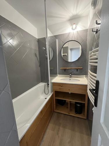 une salle de bain avec une baignoire, un lavabo et un miroir dans l'établissement Apartment Paradiski 309 - La Plagne - ski-in, ski-out, à La Plagne Tarentaise