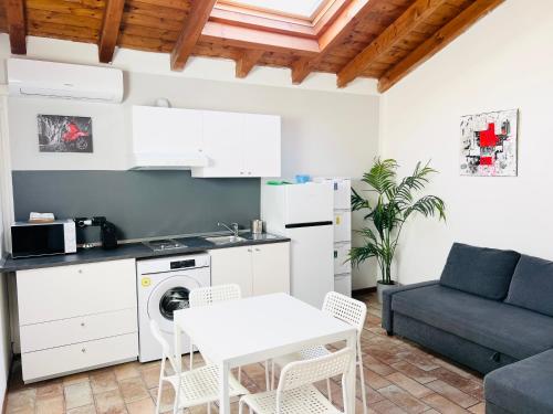 kuchnia i salon z kanapą i stołem w obiekcie Casa Cleopatra w Bergamo