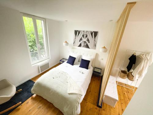 a bedroom with a white bed and a window at Appartement Rose velours in Le Mont-Dore