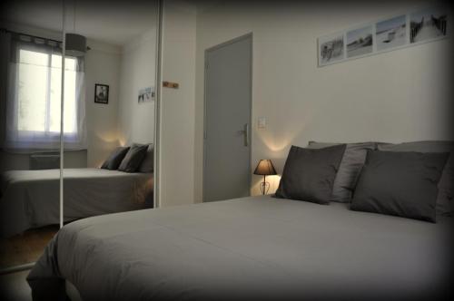 una camera da letto con un grande letto bianco e uno specchio di ''Luigi'' BALCON SUR LA MER et le Port de Sète a Sète
