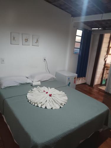 阿欽斯的住宿－Quartinho Branco，一间设有两张床的房间,床上有一个盘子
