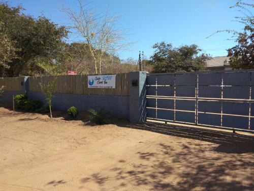 een blauw hek met een bord erop bij Chobe Blue Guest Inn in Kasane