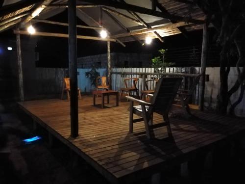 a wooden deck with a chair and a table at Chobe Blue Guest Inn in Kasane